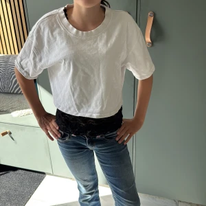 Vit croppad t-shirt från Zara - Säljer ett två delars sett men blommnät linne och en vit snygg tröja till!!Säljs separat också