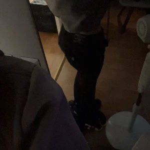 Svarta True Religion bootcut jeans - Säljer ett par svarta jeans från True Religion, modell Becca Mid Rise Bootcut. De har klassiska fickor med knappdetaljer och en snygg bootcut-passform som ger en schysst siluett. Jeansen är i midwaist och har coola detaljer på bakfickan.