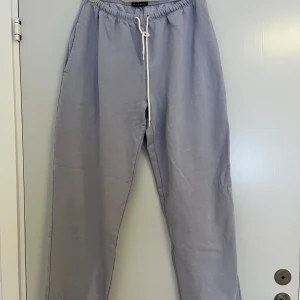 Ljuslila mjukisbyxor Brandy Melville - Säljer ett par ljuslila mjukisbyxor från Brandy Melville med vit snörning i midjan och elastisk resår. Byxorna har en loose passform och är tillverkade i mjukt bomullsmaterial med fleece på insidan. Perfekta för chill dagar och häng med kompisar.
