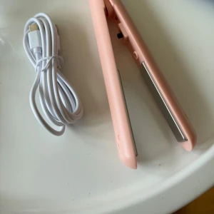 Rosa plattång med USB-kabel - Rosa platttång! En mindre variant så den kommer ner i väskan osv, säljer då jag aldrig använt den 💕