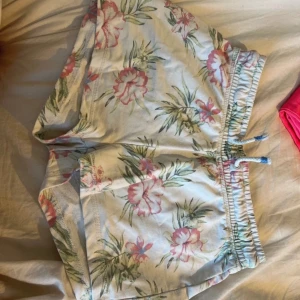 Blommiga shorts med snörning - Storlek: 158/164 (13-14yrs)  Måste sälja av allt jag lägger upp för har flyttat! Pris går alltid att diskutera! Djur fanns i hemmet! Finns på fler hemsidor!