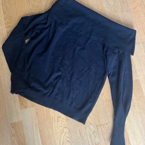 Svart offshoulder tröja NA-KD - Svart offshoulder tröja från NA-KD designad av Kristin Sundberg. Tröjan har långa ärmar och bred kant upptill som ger en snygg offshoulder-look. Mjuk och skön kvalitet, perfekt att styla med jeans eller kjol. Ribbad nederkant och ärmslut för extra komfort.