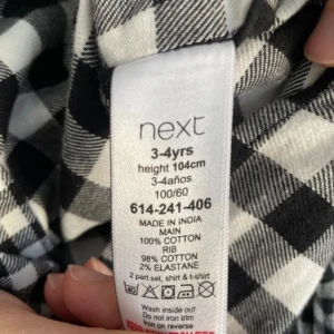 Svartvit rutig långärmad tröja från Next - Säljer en svartvit rutig långärmad tröja från Next i bomull. Tröjan har rund halsringning, bröstficka och ett coolt rutigt mönster i olika storlekar på varje sida. Perfekt för dig som gillar unika plagg!