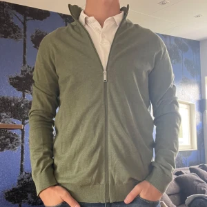 Grön zip up - Soft grön zip up från Selected Homme. Knappt använd så i princip nyskick🤩👍🏼 Storlek M och normal i passformen. Go att slänga över en vit skjorta eller liknande nu t sommaren ☀️Skriv vid frågor eller funderingar!