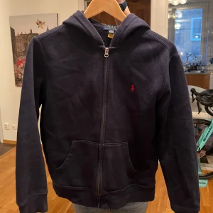 Zip hoodie från Polo Ralph Lauren - Säljer en blå zip hoodie i bra skick från Ralph Lauren. Storlek Barn L (14-16 år). Bara att höra av vid minsta fundering!🙏🙌