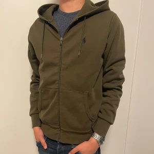 Polo Ralph Lauren zip hoodie - Tja, säljer en helt ny olivgrön hoodie från Ralph lauren som har andvänts ett fåtal gånger. Nypris ligger på ca 2200kr. Priset är hugget i sten! 
