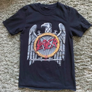 Svart Slayer t-shirt - Cool svart t-shirt med stort Slayer-tryck på, säljer eftersom jag knappt använder den längre. Jag köpte den på Blue Fox. Det passar både män och kvinnor!
