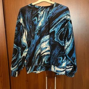 Blå och svart mönstrad tröja från Sweet Skts - Cool långärmad tröja från Sweet Skts med blått, svart och vitt marmorerat mönster. Oversized passform och rund halsringning. Storlek s🥰