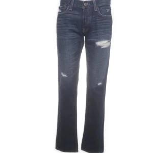 Mörkblå bootcut jeans med slitningar - Snygga mörkblå jeans med bootcut passform och slitna detaljer på framsidan. Jeansen är från hollister och i nyskick 