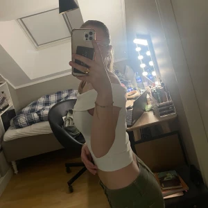 Vit offshoulder croppad topp - Säljer en vit croppad topp med offshoulder-design. Skit snygg men används tyvärr inte längre. Är i storlek S men passar från xxs-s 