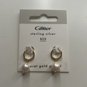 Guldpläterade örhängen med pärlor från Glitter - Snygga örhängen i sterling silver 925 med 18 karat guldplätering och hängande vita pärlor. Perfekta för att ge en elegant touch till din stil. Kostar 300 helt nya❤️