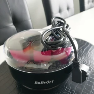BaByliss elektriska värmespolar - Säljer en BaByliss elektrisk värmespolar-set för att skapa volym och lockar. Setet innehåller flera rosa och svarta spolar i en rund svart värmebehållare med genomskinligt lock. Perfekt för att fixa snygga lockar snabbt och enkelt hemma.
