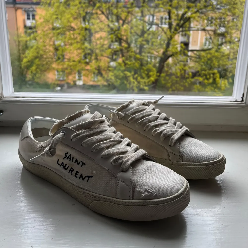 Vita skor från Saint Laurent, storlek 40 men sitter som 41, innermått 26 cm, mycket bra skick förutom att flärpen är lite blå men inget som syns vid användning, tyget är lite smutsigt men inget som inte går o fixa, skriv vi frågor. Kengät.
