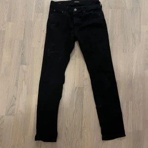 Svarta jeans från Jack & Jones - Säljer ett par svarta jeans från Jack & Jones. Klassisk femficksmodell med knapp och dragkedja i gylfen. Jeansen har en rak passform och är tillverkade i ett mjukt bomullsmaterial med lite stretch för extra komfort. strlk 30/30 pm f mer info