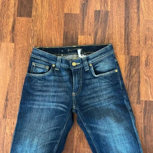 Mörkblå jeansbyxor från denimbirds - Säljer ett par klassiska mörkblå jeans från denimbirds med snygga slitningar och kontrastsömmar. Byxorna har fem fickor, gylf med dragkedja och knapp samt logga  på bakfickan. Perfekta till vardags! Aldrig använda, lågmidjade och priset kan diskuteras 