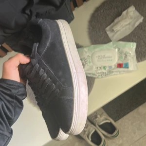 Svarta sneakers från Vagabond - Säljer ett par svarta sneakers från Vagabond med ovandel i mocka och klassisk snörning. Skorna har en vit, platt sula och rund tå. Perfekta för en stilren och enkel look.