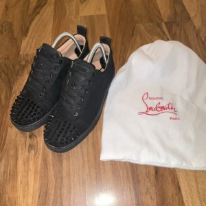 Svarta Christian Louboutins med spikar - Christian Louboutins med spikar i storlek 40/41 kommer i påse och mockan i dunder skick, Använda och det syns lite på sulorna men trotts det är den röda färgen bra och texten syns ordentligt, härliga skor som passar till allt och ifall du vill sticka ut är dessa ett måste! Pris kan diskuteras!!!!!