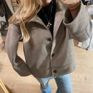 Beige kappa med knappar - Säljer en snygg beige kappa i mycket bra skick. Väldigt eftertraktad ❤️❤️ har en svag vit fläck, har inte testat att få bort den men det går troligen. :)