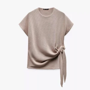 Beige topp med knyt - Säljer en beige stickad topp från Zara med korta ärmar och rund hals. Toppen har en snygg knytdetalj i sidan. Helt slutsåld på hemsidan. Använd fåtal gånger💗
