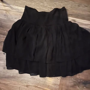 Svart volangkjol från Saint Tropez - Säljer en svart kortkjol från Saint Tropez i storlek L. Säljer då jag tagit bort lappen innan jag insåg att jag fått fel storlek. Nypris 599kr