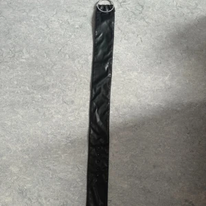 Brett svart bälte med strasspänne - Oanvänd och skickar iväg samma dag eller dagen efter🙌🏼Snyggt brett bälte i svart skinnimitation med ett stort runt spänne dekorerat med strass. Bältet har flera hål för justering och ger en cool statement-look till outfiten. Perfekt för att lyfta en klänning eller oversized skjorta.