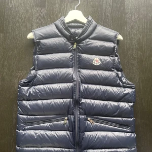 Moncler Gui Vest Navy  - Säljer nu ut lite kläder vi på Brandofnordic HB inte blivit av med.  Det är en Moncler Gui vest i Navy blå. Storlek är 2, så S/M. Den är i ny skick och taggar/ original påse medföljer. Säljer den för 1200 kr. Bara att fråga efter mer bilder. 