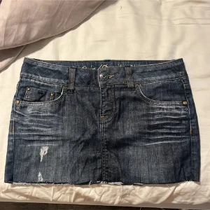 Mörk jeanskjol från Esprit - Snygg mörkblå jeanskjol från Esprit med slitna detaljer och rå kant nertill. Storlek 27 men sitter som en S midjemått: 40 cm