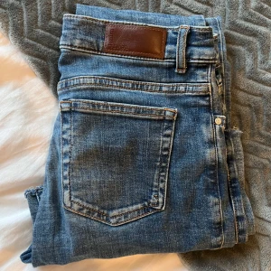 Blå low flare jeans med råa kanter - Snygga blå jeans från BIKBOK i modellen low flare. Jeansen har låg midja