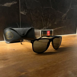 Ray-Ban boyfriend solglasögon - Helt nya Snygga svarta Ray-Ban RB4147 solglasögon med klassisk fyrkantig form och blått  glas. Tillverkade i Italien och kommer med originalfodral och putsduk. Perfekta för dig som vill ha en tidlös och cool look i solen. OBS glaset är blått! Syns tydligare på sista bilden och för bilder i bättre ljus är det bara att skriva :)