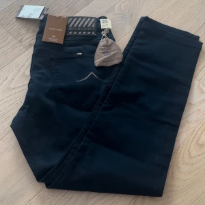 Jacob Cohën mörkblå jeans Bard - Snygga mörkblå jeans från Jacob Cohën, modell Bard. Byxorna har klassisk femficksdesign, guldfärgade detaljer och broderad J på myntfickan. Tillverkade i mjuk bomullsmix med dragkedja och exklusiva detaljer på insidan. Limited edition.