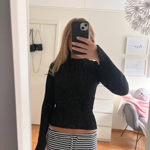 Svart ribbad stickad tröja - Säljer en svart ribbad stickad tröja med lång ärm och lätt utsvängda ärmar. Tröjan har en tight passform och är i mjukt material. Perfekt som festtröja under hösten/vintern. Pris kan absolut diskuteras 