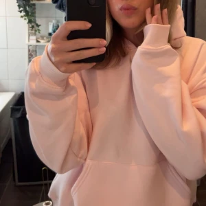 Ljusrosa hoodie från Gina Tricot - Supermysig ljusrosa hoodie från Gina Tricot, oversized fit med stor känguruficka och huva. Mjuk bomullsblandning som känns skön mot huden. Använd endast 1 gång🩷