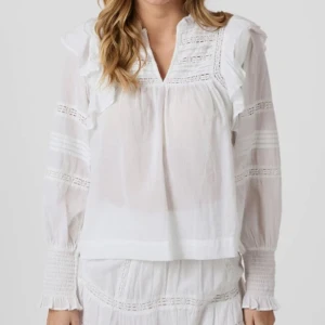 Vit volangblus med spetsdetaljer - Superfin vit blus i romantisk stil med spets- och volangdetaljer. Något genomskinlig, perfekt till både vardag och fest. Använd ett fåtal gånger, i mycket fint skick. 🤍🤍