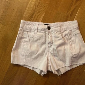Vita shorts från We Love Jeans stl 34 - Säljer ett par vita shorts från We Love Jeans. De har en knapp framtill och praktiska fickor både fram och bak. Perfekta för varma sommardagar! 🌞