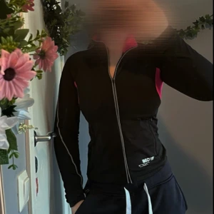 Svart träningsjacka - Säljer en svart träningsjacka från Kappahl med dragkedja och rosa detaljer. Jackan har en tight passform och är perfekt för träning. Den har långa ärmar och en hög krage för extra komfort. Det står att den är i storlek 146/152 men skulle mer säga att den är för XS/S då jag som storlek S kan ha på mig den💕💞
