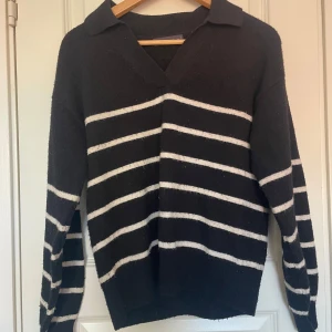 Svart och vit randig tröja från M&S Collection - Tunn stickad tröja med krage upptill och långa ärmar. Den är hanska nopprig men utöver det är den i bra skick. 