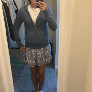 Blåvit blommig kjol - Söt blåvit kjol med blommigt mönster. Perfekt för varma dagar med sin luftiga design. Kjolen har en avslappnad passform och är lätt att matcha med olika stilar. I strl 152 men passar mig som har xs/s