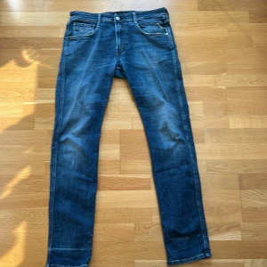 Jättesnygga Replay jeans - Snygga blå jeans från Replay med en klassisk femficksdesign och en lätt slitning för en cool look. De har en knappgylf och bälteshällor. 34/34 i storlek.✅Perfekta för en avslappnad stil. Slitningarna höjer utseendet och är väldigt populärt💯. Skriv till mig vid frågor och funderingar så svarar jag gärna😊 