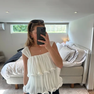 Vit ärmlös blus - Säljer denna superfina toppen från NAKD x Lojasan Wallin. Den har ett superfint fall och sitter superbra! 🤍