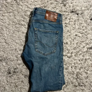Blå jeans slim/straigth - Snygga blå jeans från Jack & Jones med slim straight passform. Längd 30 midja 29. Perfekta för en stilren look. Passar perfekt nu till sommarn med ljus ferg för att klara av värmen.