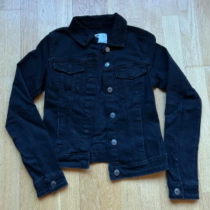 Svart jeansjacka från Bershka - Snygg svart jeansjacka från Bershka med klassisk krage och knappar framtill. Har endast använts 2 gånger då den är för liten! Bild när jag hade den på sista bilden! 🖤 perfekt nu till sommaren. 99% bomull