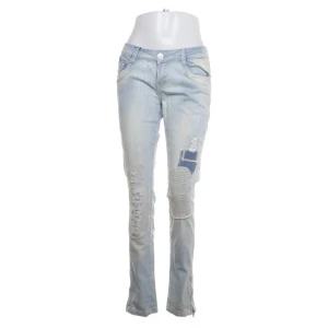 Ljusblå jeans med patchwork - Har ingen bild på då dom ej passar!Snygga ljusblå jeans med unika patchwork-detaljer och slitningar. De har en knappstängning och klassisk femficksdesign. Perfekta för en avslappnad stil med en twist.