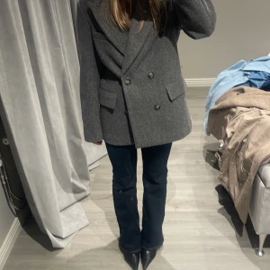 Grå kavaj från Gina Tricot - Säljer en stilren grå kavaj från Gina Tricot i storlek S den är litte noppig som man ser på bild därav priset