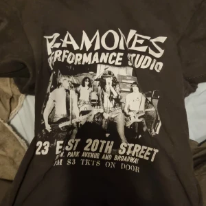 Svart Ramones t-shirt från H&M Divided - Cool svart t-shirt från H&M Divided med Ramones-tryck på framsidan. Perfekt för dig som älskar klassisk rockstil. T-shirten har korta ärmar och en normal passform. Ett måste för alla Ramones-fans! 🎸