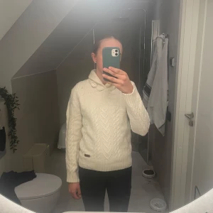 Vit stickad tröja - Superskön tröja i vad jag skulle tro ull då den krymt lite i huvudet tvätten. Passar nu som xs. Nypriset ligger på ca 1000 kr. Finns ett litet hål under kragen, skickar bild vid intresse:)