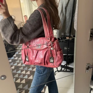 Rosa axelväska - Super snygg rosa axelväska med krokodilmönster och silverdetaljer. Säljer då den inte kommer till användning men perfekt för dig som vill ha enfärgklick till din outfit💕
