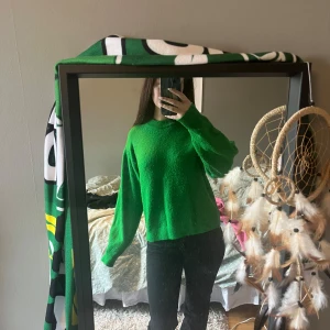 Grön tröja - Säljer en snygg grön tröja från H&M. Tröjan har en normal passform med långa ärmar och är perfekt för både höst och vår. Den är tillverkad i ett mjukt material som gör den bekväm att bära. Perfekt för att liva upp garderoben med lite färg! 💚