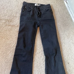Svarta bootcut jeans från 157 - Svarta jeans från 157 med bootcut-passform. Klassisk femficksmodell med dragkedja och knapp framtill samt fickor med lock bak. Perfekta för dig som gillar en tidlös stil.