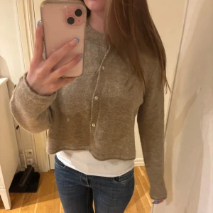 Beige kofta från Zara - Säljer en beige croppad kofta från Zara i mjuk alpacka- och ullblandning. Koftan är i nyskick med prislapp kvar. Nypris: 399kr. 