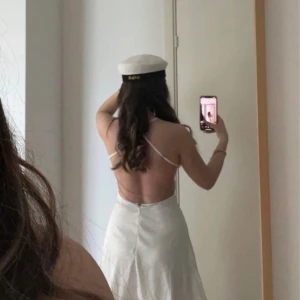 Vit axelbandslös klänning - Säljer en söt vit klänning med tunna axelband och öppen rygg. Använt en gång för studenten:)